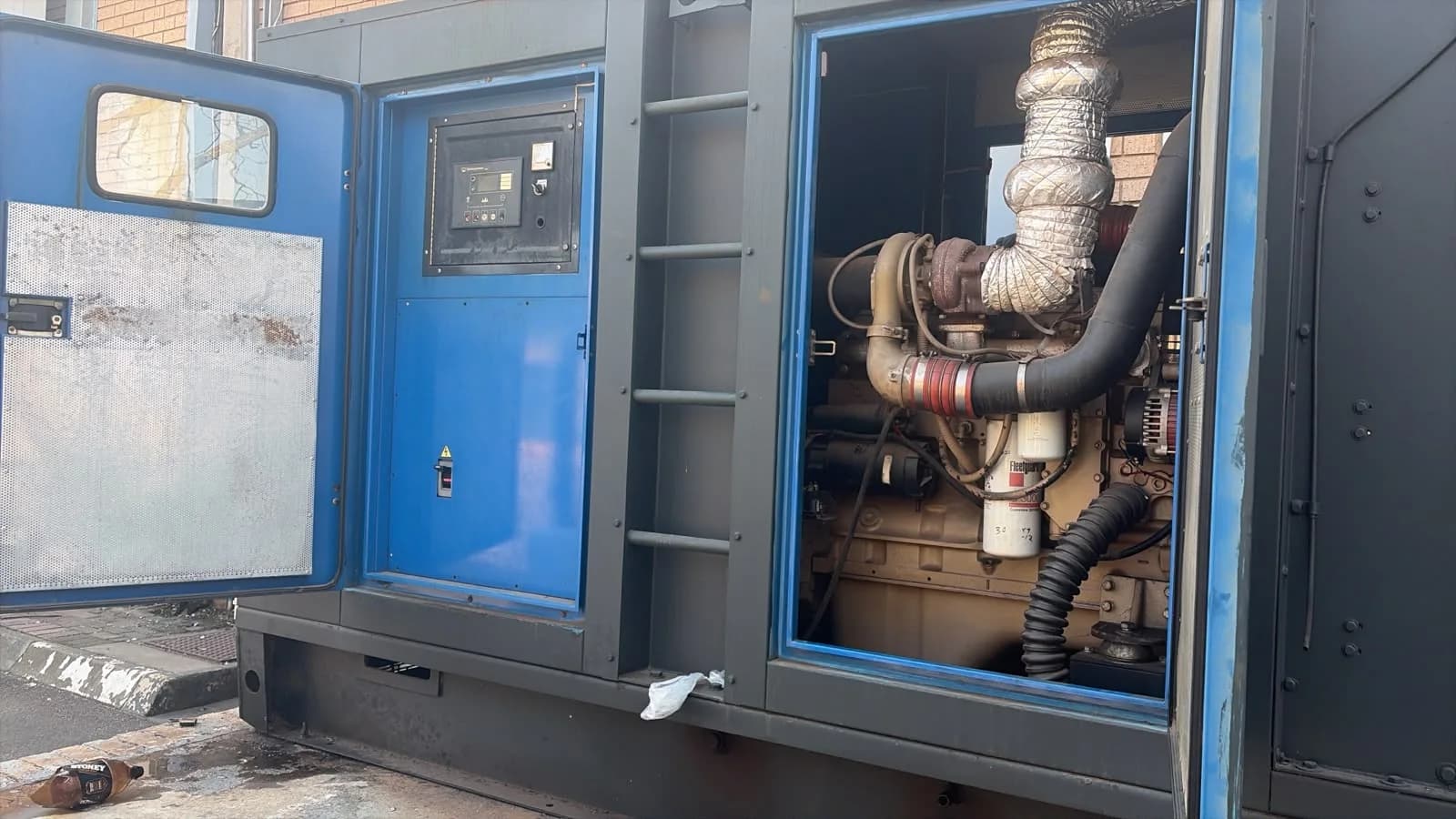 Two technicians inspecting a large diesel generator