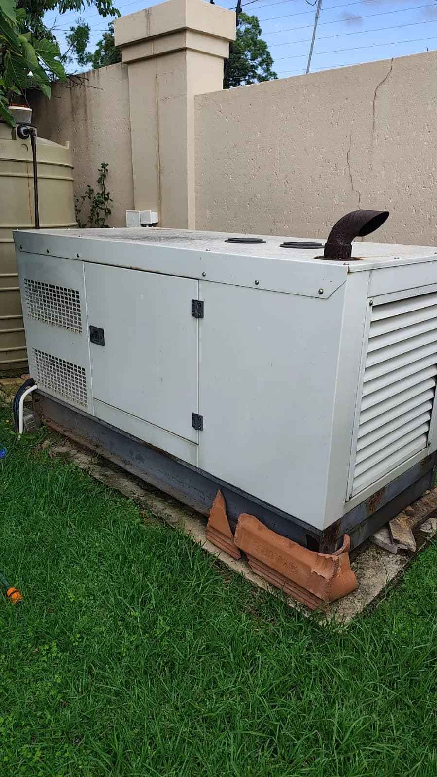 Two technicians working on a large commercial generator