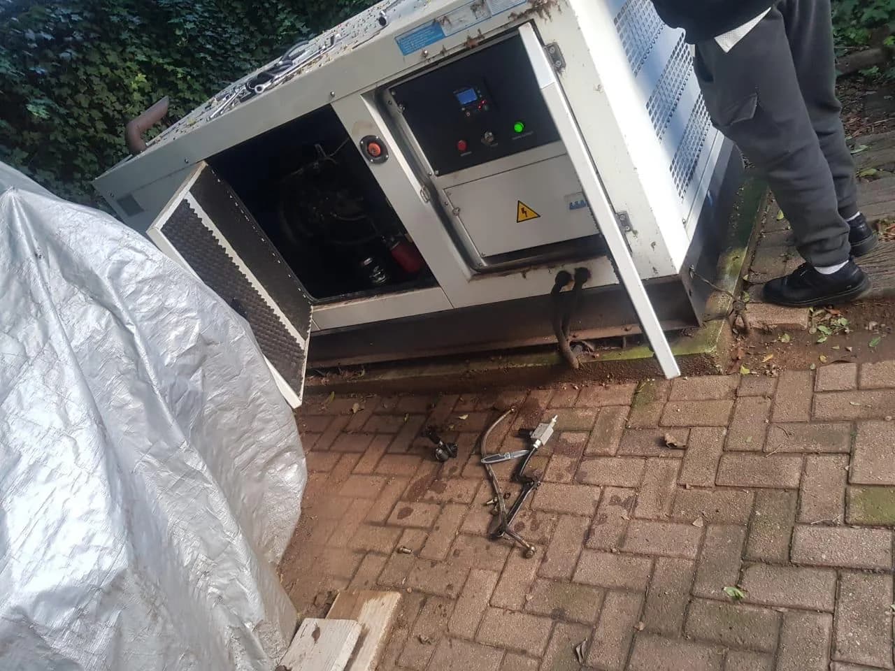 Two technicians working on a medium standby generator