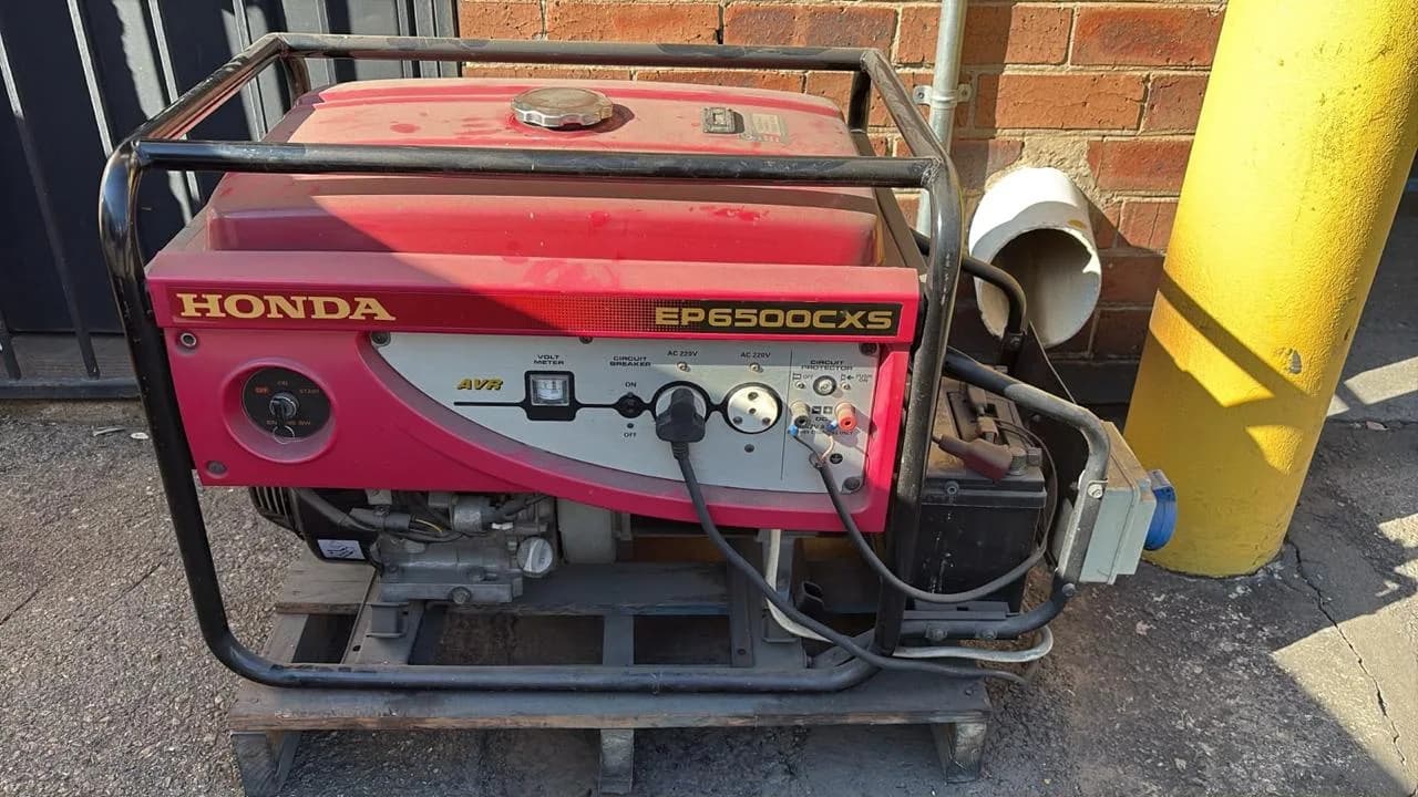 Technician inspecting a compact portable petrol generator