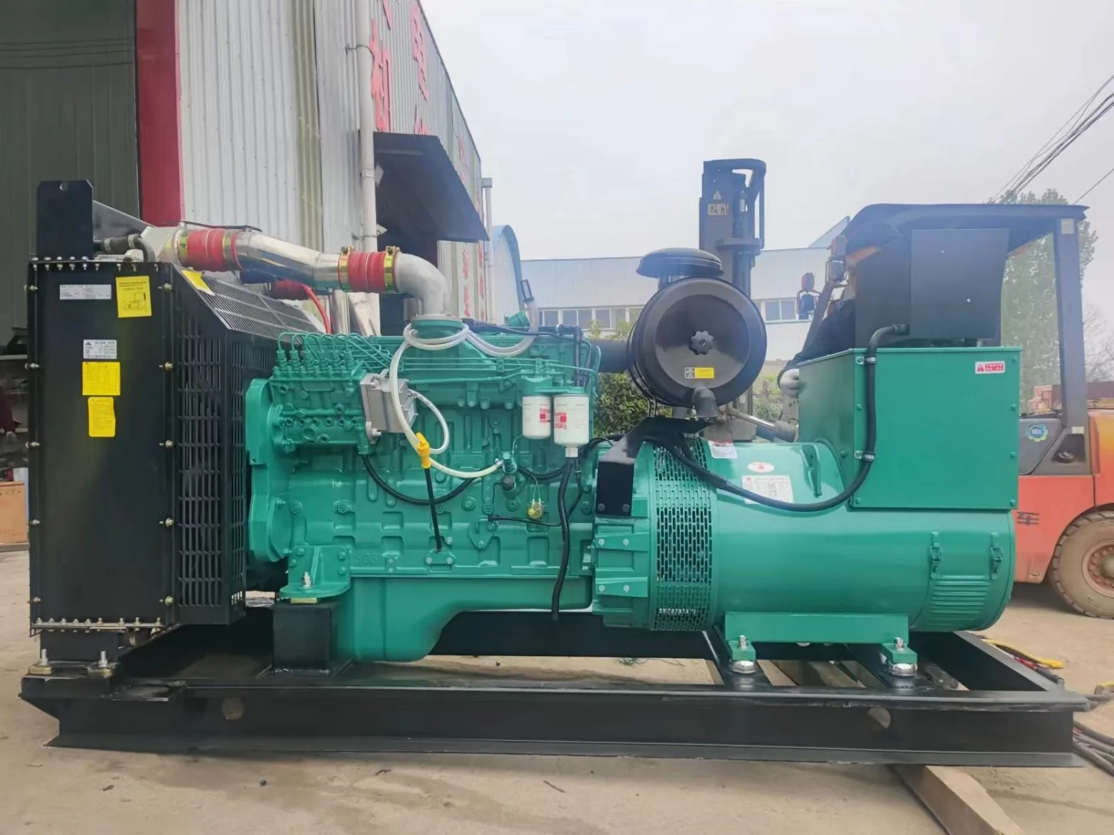 Two technicians diagnosing a diesel standby generator beside a larger diesel set