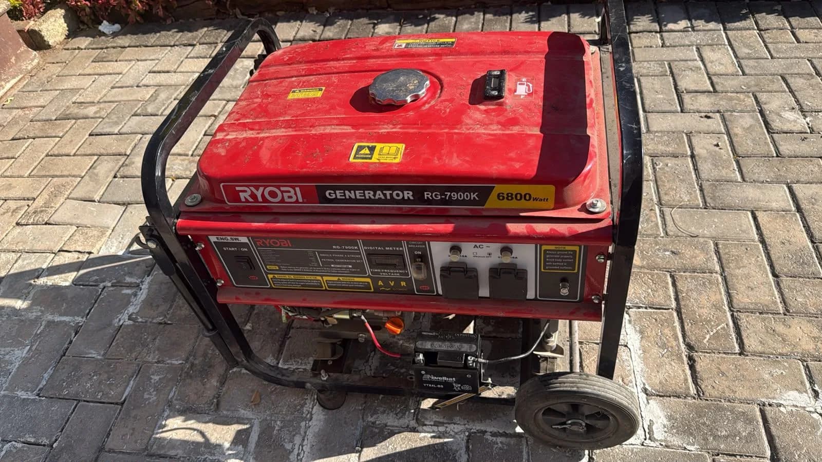 Ryobi portable petrol generator being inspected